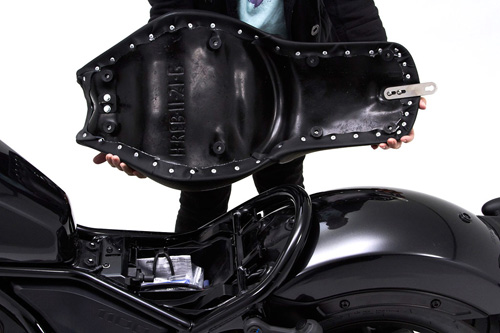 a person holding Gunfighter seat showing the back side, MPN printed and mounting brackets pre-installed