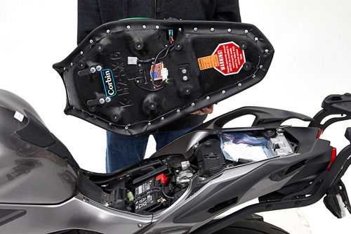 a person holding Front & Rear seat showing the back side heater wiring, MPN printed and mounting brackets pre-installed