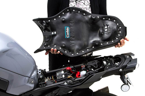 a person holding Gunfighter & Lady seat showing the back side, MPN printed and mounting brackets pre-installed