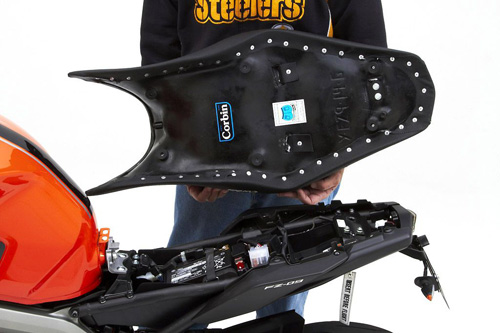 a person holding Gunfighter seat showing the back side, MPN printed and mounting brackets pre-installed