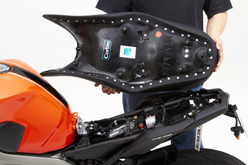 a person holding Gunfighter & Lady seat showing the back side, MPN printed and mounting brackets pre-installed
