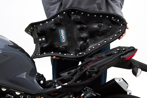 a person holding Gunfighter seat showing the back side, MPN printed and mounting brackets pre-installed