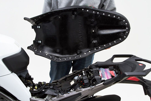 a person holding Gunfighter & Lady seat showing the back side, MPN printed and mounting brackets pre-installed
