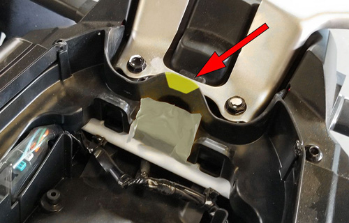 arrow shown pointing toward the plastic under the seat, that need to be removed