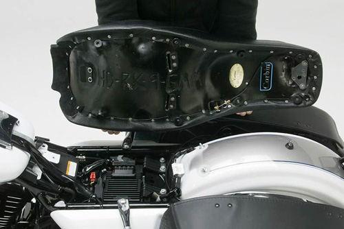 a person holding Gambler seat showing the back side heater wiring, MPN printed and mounting brackets pre-installed