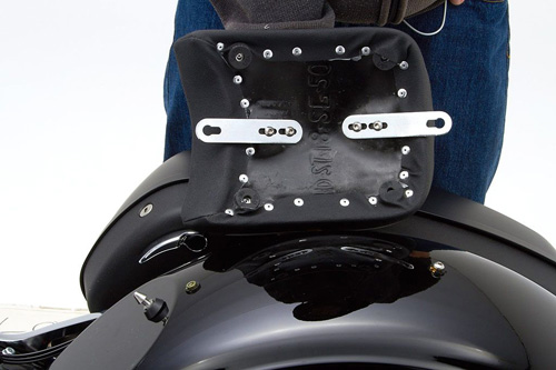 a person holding Rear seat showing the back side, MPN printed and mounting brackets pre-installed