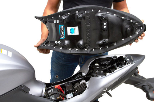 a person holding Gunfighter seat showing the back side, MPN printed and mounting brackets pre-installed