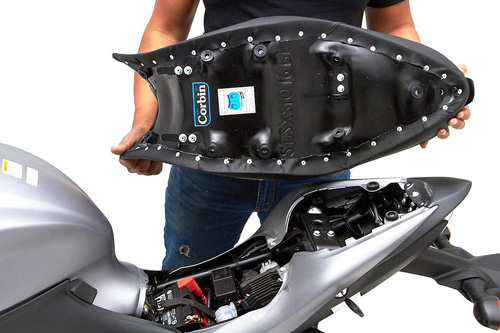 a person holding Gunfighter & Lady seat showing the back side, MPN printed and mounting brackets pre-installed