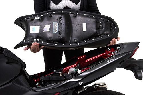 a person holding Gunfighter & Lady seat showing the back side, MPN printed and mounting brackets pre-installed