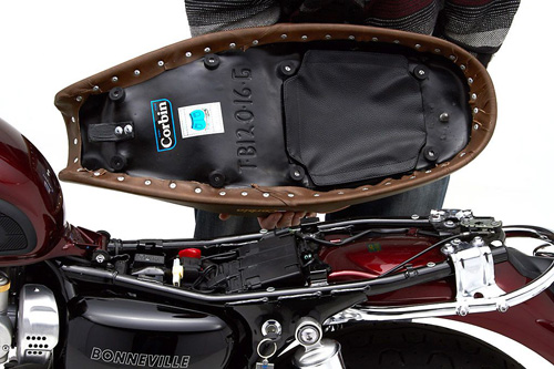 a person holding Classic Gunfighter seat showing the back side, MPN printed and mounting brackets pre-installed