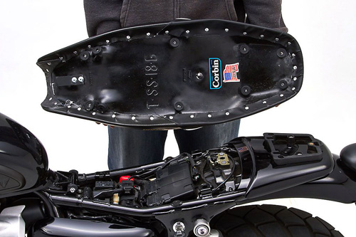 a person holding Gunfighter seat showing the back side, MPN printed and mounting brackets pre-installed