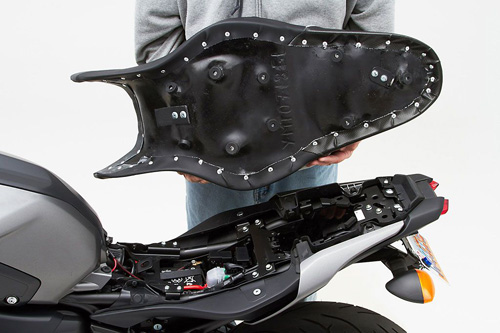 a person holding Gunfighter seat showing the back side, MPN printed and mounting brackets pre-installed
