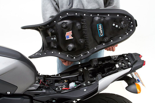a person holding Gunfighter & Lady seat showing the back side, MPN printed and mounting brackets pre-installed