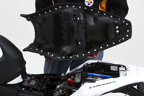 a person holding Gunfighter seat showing the back side, MPN printed and mounting brackets pre-installed