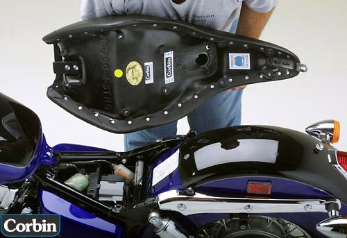 a person holding Stinger seat showing the back side, MPN printed and mounting brackets pre-installed