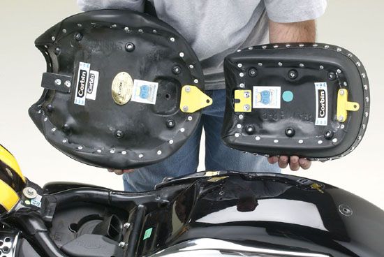 a person holding Front & Rear seat showing the back side, MPN printed and mounting brackets pre-installed