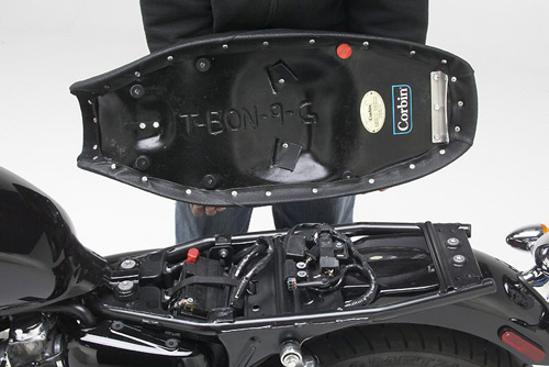 a person holding Gunfighter seat showing the back side, MPN printed and mounting brackets pre-installed
