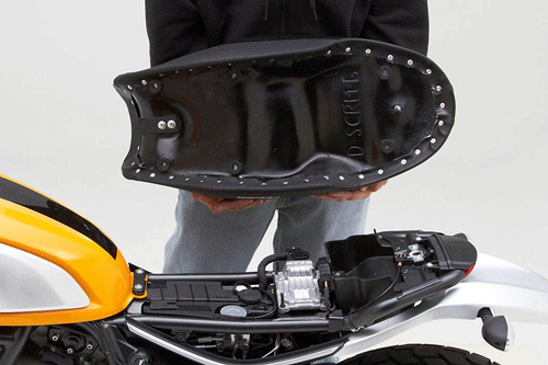 a person holding Gunfighter seat showing the rear side, MPN printed and mounting brackets pre-installed