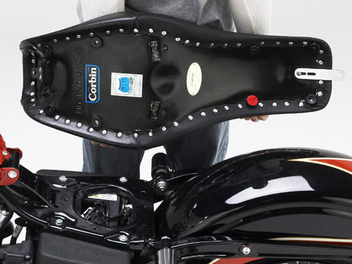 a person holding Close Gunfighter seat showing the rear side, MPN printed and mounting brackets pre-installed