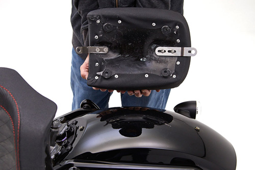 a person holding Pillion Pad showing the rear side mounting brackets pre-installed