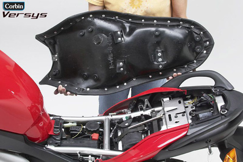 a person holding Canyon Dual Sport seat showing the rear side, MPN printed and mounting brackets pre-installed