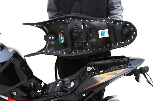 a person holding Gunfighter seat showing the back side, MPN printed and mounting brackets pre-installed