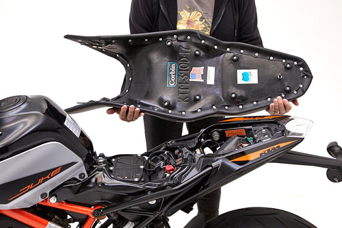 a person holding Dual seat showing the back side, MPN printed and mounting brackets pre-installed