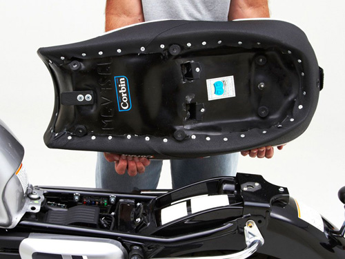 a person holding Vintage Gunfighter seat showing the rear side, MPN printed and mounting brackets pre-installed