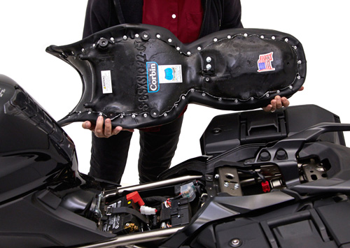 a person holding Gunfighter & Lady seat showing the rear side, MPN printed and mounting brackets pre-installed