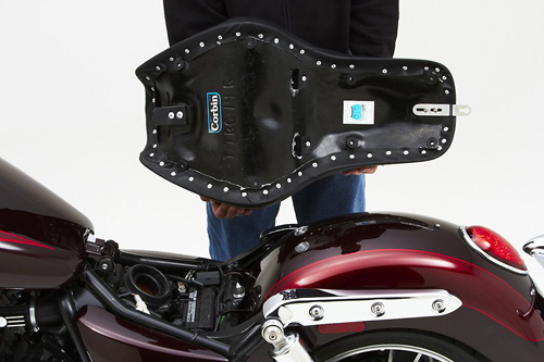 a person holding Gunfighter seat showing the back side, MPN printed and mounting brackets pre-installed