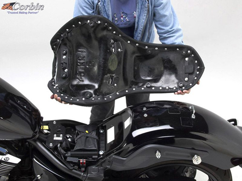 a person holding Gunfighter seat showing the rear side, MPN printed and mounting brackets pre-installed