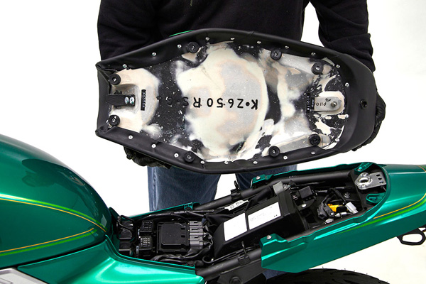 a person holding Gunfighter seat showing the rear side with MPN printed and mounting brackets pre-installed