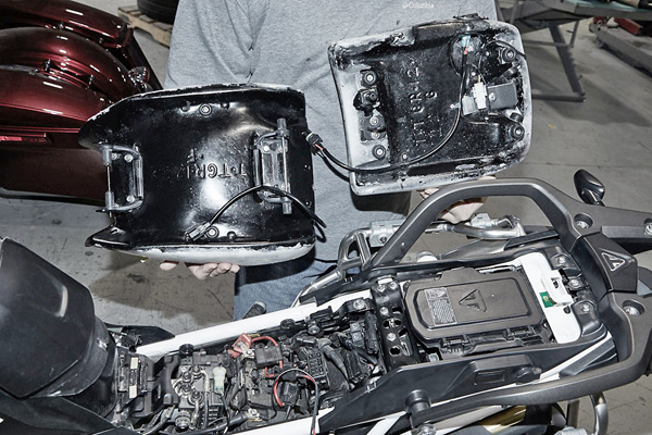 a person holding Front & Rear seat showing the rear side, MPN printed, heater wiring harness and mounting brackets pre-installed