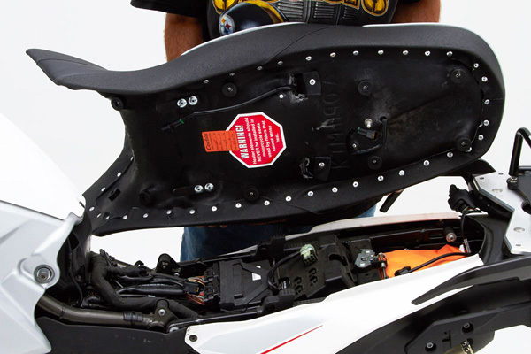 a person holding Canyon Dual Sport seat showing the rear side with MPN printed and mounting brackets pre-installed