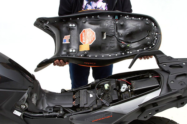 a person holding Canyon Dual Sport seat showing Wiring connector for heat model
