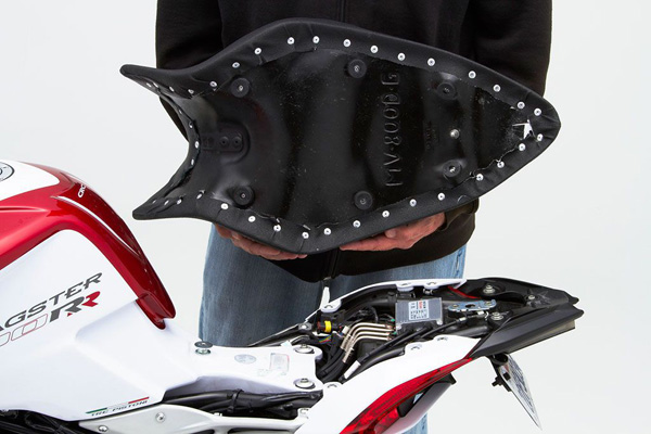 a person holding Gunfighter seat showing the rear sides with MPN printed and mounting brackets pre-installed