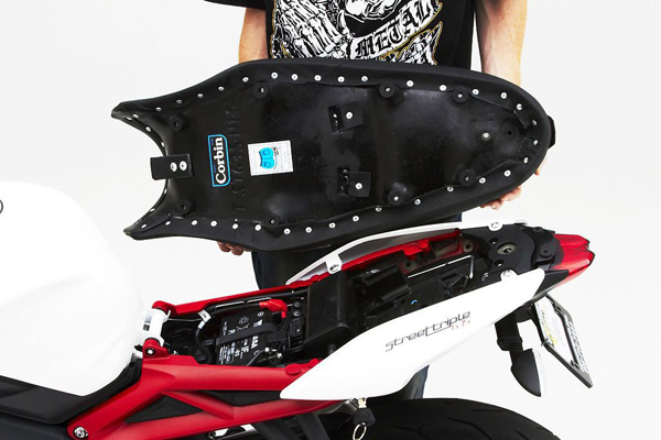 a person holding Gunfighter & Lady seat showing the rear side with MPN printed and mounting brackets pre-installed