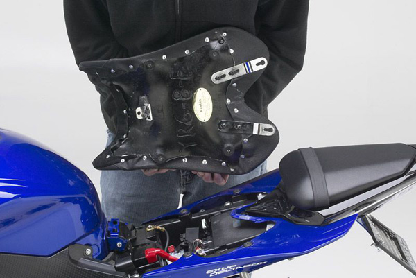 A person holding Front seat showing the rear side with MPN printed, brackets and tongue