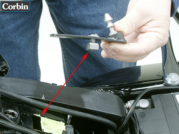 a person holding latch pin bracket and a red arrow showing where to install
