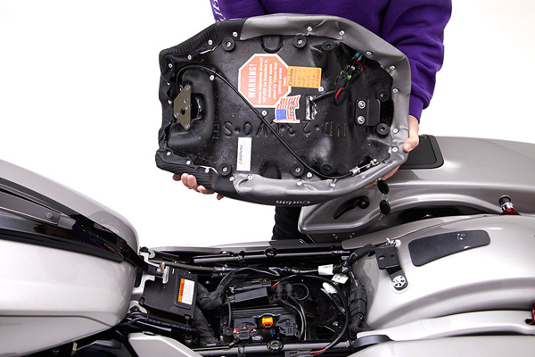 a person is holding solo seat showing the rear side mounting tabs