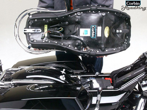 a person is holding Dual tour seat's rear side showing mounting brackets