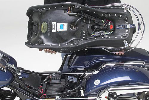 a person is holding Dual Touring seat showing rear side mounting brackets pre-installed