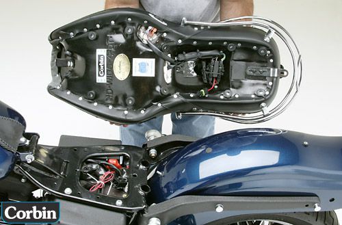 a person is holding Dual Tour seat showing rear side MPN printed, Heater wiring harness and mounting brackets pre-installed