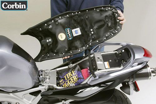 a person is holding Gunfighter seat showing rear side with MPN printed and mounting brackets pre-installed