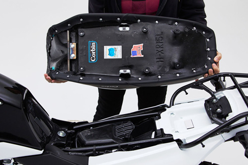 a person is holding Dual seat showing rear side MPN printed and mounting brackets pre-installed