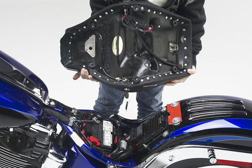 a person is holding solo seat with rear side MPN printed, heater wiring and mounting brackets pre-installed