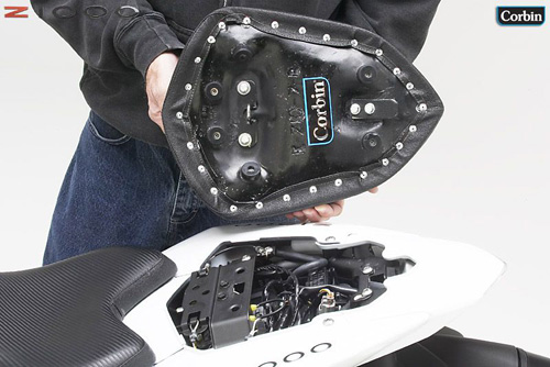 a person is holding rear seat showing basepan with MPN printed and mounting brackets pre-installed