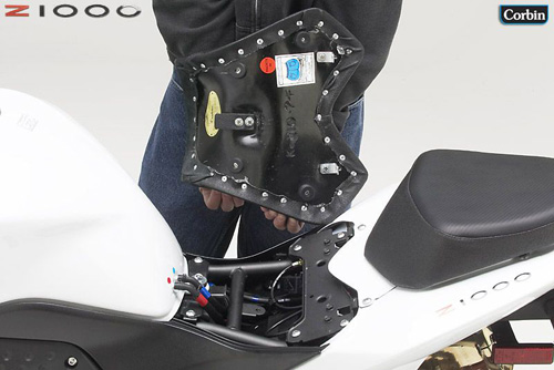 a person is holding front seat showing basepan with MPN printed and mounting brackets pre-installed