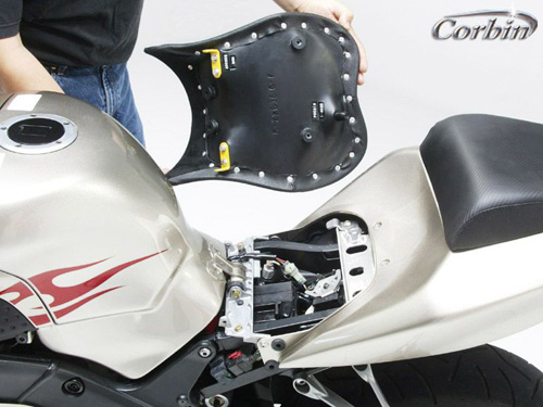 a person is holding front seat showing basepan with MPN printed and mounting brackets pre-installed