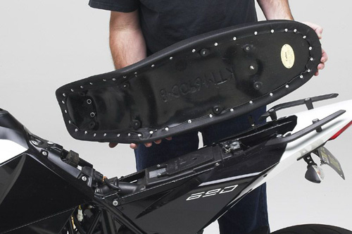 a person is holding Dual seat showing rear side MPN printed and mounting brackets pre-installed